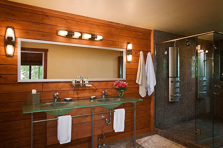 Sleek log home bath room with glass counter top