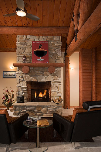 Leather furniture in log home sitting in front of fireplace